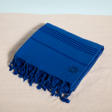 Joie de Vivre keyf Turkish beach towel folded with logo on sand